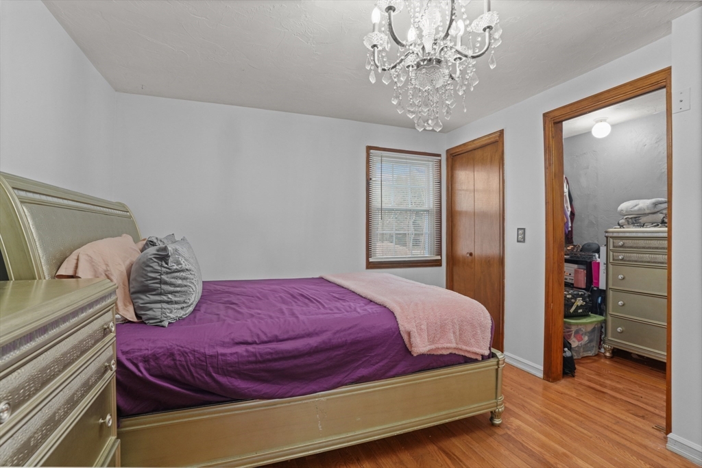 500 Hancock Street Fall River, MA 02721 - Photo 18 of 33 a bedroom with a bed and a chandelier