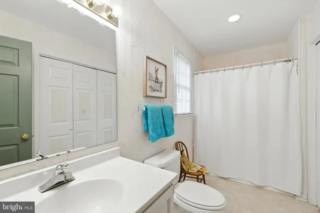 a bathroom with a sink vanity mirror and toilet
