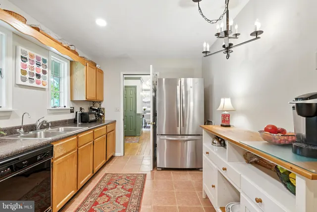 a kitchen with stainless steel appliances a sink cabinets and wooden floor