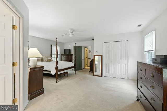 a spacious bedroom with a bed a couch and dresser