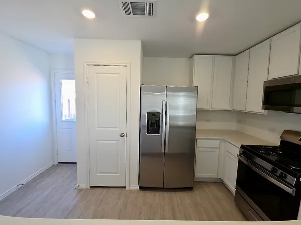 a kitchen with stainless steel appliances granite countertop a refrigerator microwave and stove