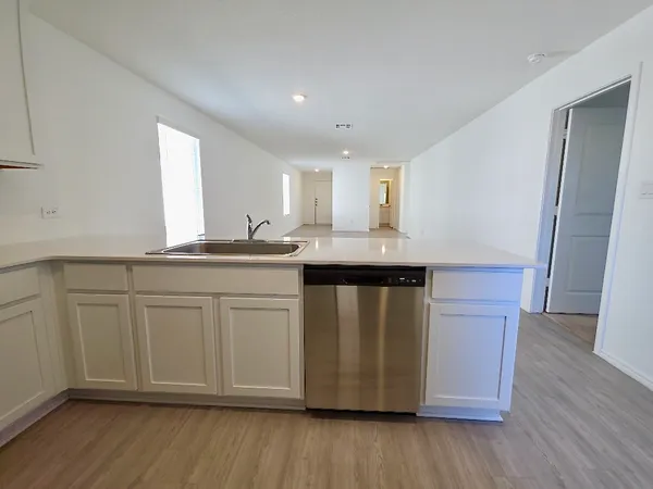 a kitchen with granite countertop white cabinets and wooden floor