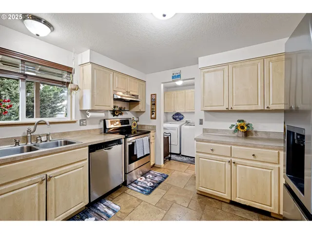 a kitchen with granite countertop a sink stainless steel appliances and cabinets
