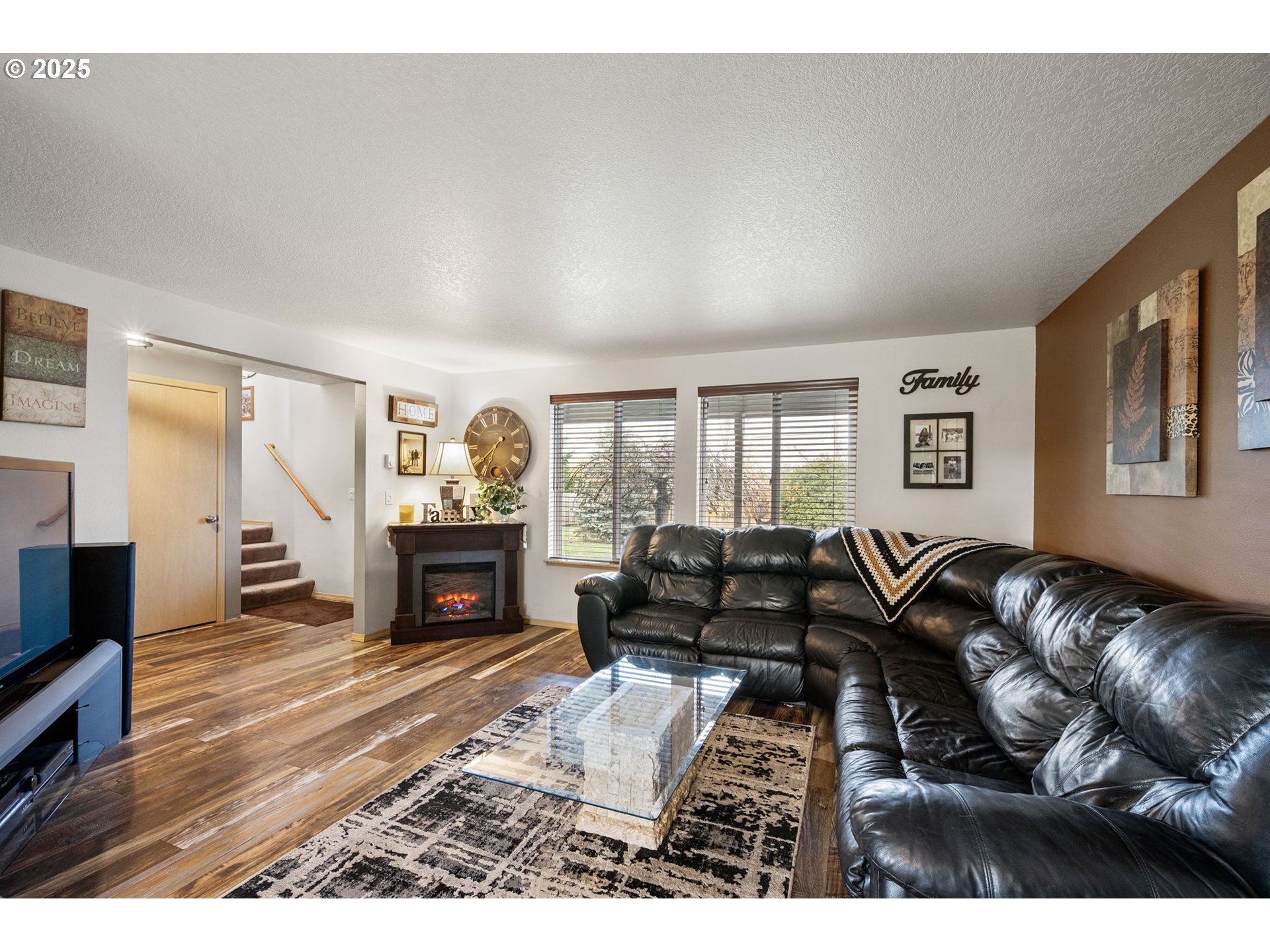 32968 Camas Swale Road Creswell, OR 97426 - Photo 6 of 44 a living room with furniture a fireplace and a flat screen tv