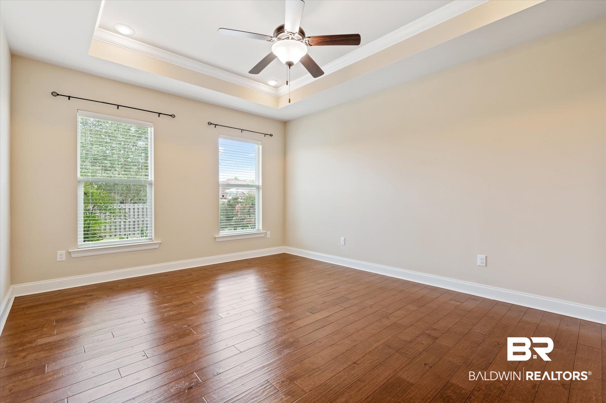 423 Breckin Drive Fairhope, AL 36532 - Photo 13 of 31 Primary bedroom featuring a tray ceiling, ceiling fan, dark hardwood / wood-style floors, and crown molding