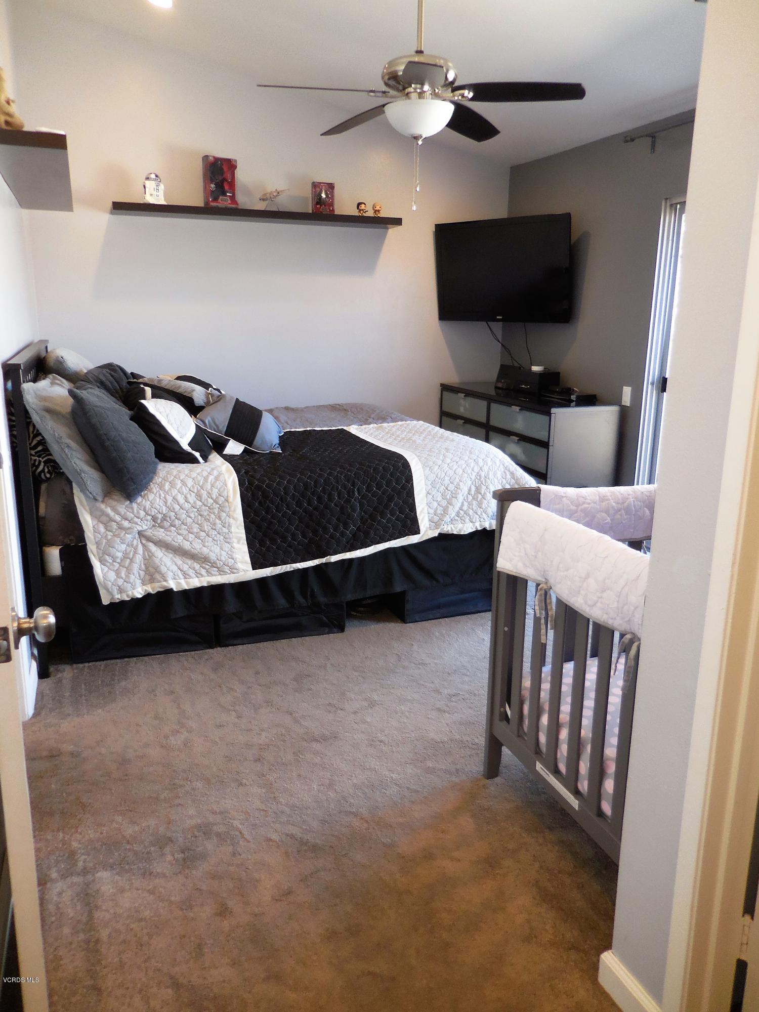 5197 Perkins Road Oxnard, CA 93033 - Photo 22 of 26 a bedroom with furniture and a flat screen tv