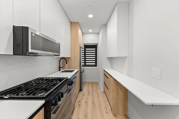 a kitchen with granite countertop a stove and a sink