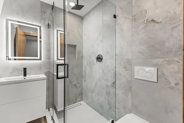 a bathroom with a sink mirror and shower