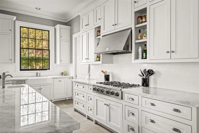 a kitchen with white cabinets and window