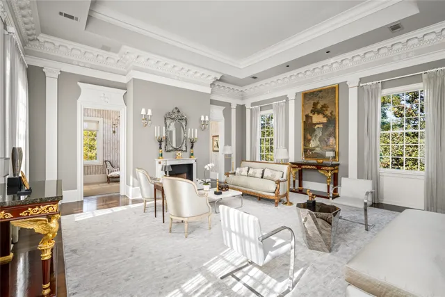 a living room with furniture a fireplace and large windows