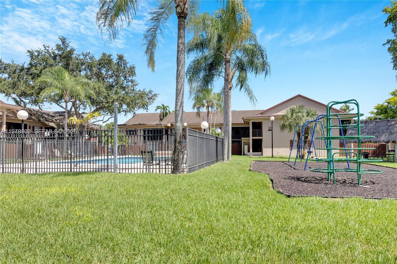 11273 Southwest 88th Street, Unit 114J Miami, FL 33176 - Photo 18 of 19 a front view of a house with a garden and patio