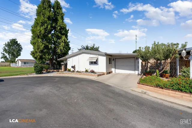 a view of a white house with a yard and garage