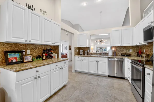 a kitchen with white cabinets and white appliances