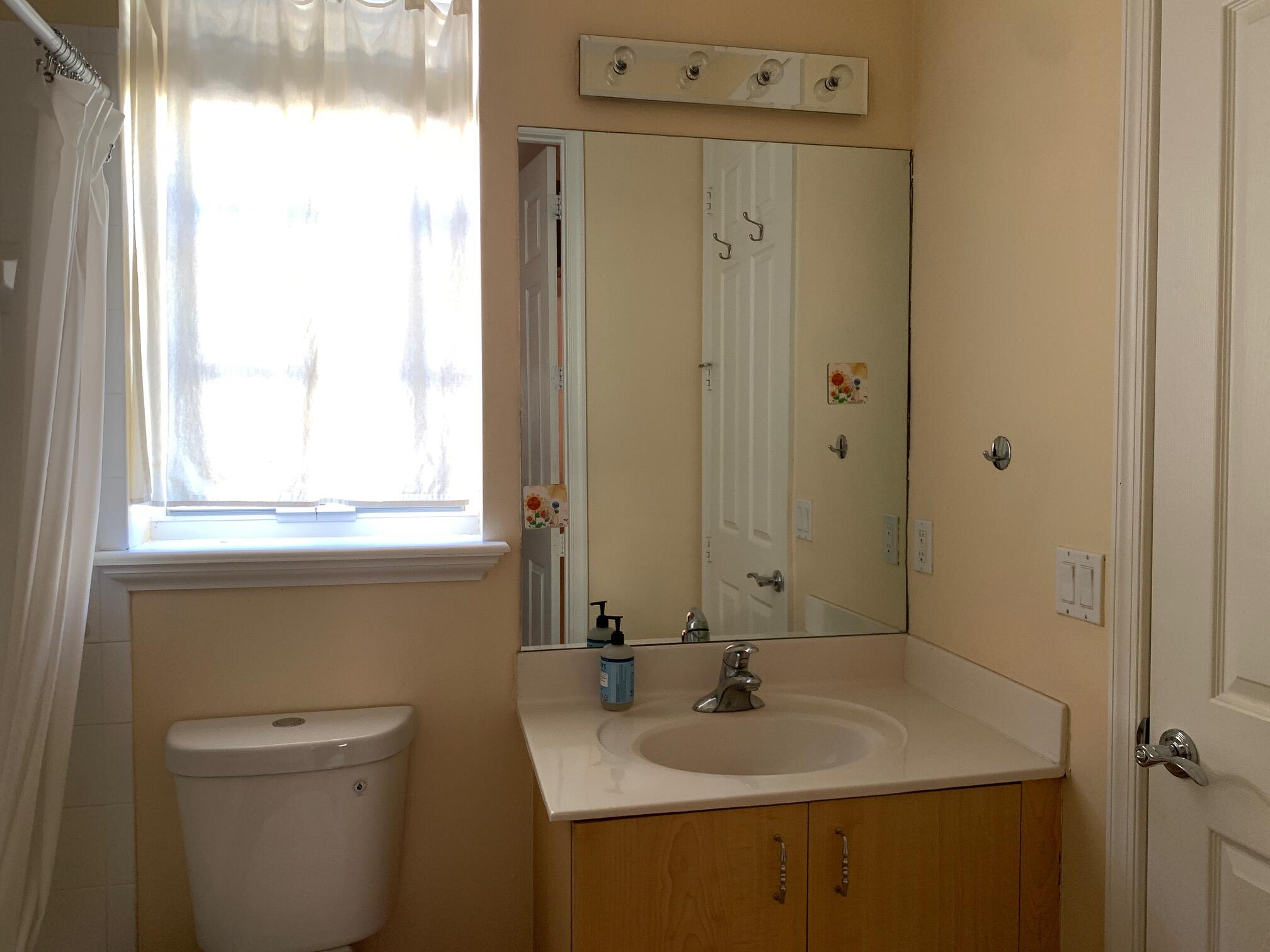 145 Morning Dew Circle Jupiter, FL 33458 - Photo 11 of 12 a bathroom with a sink a toilet and a mirror