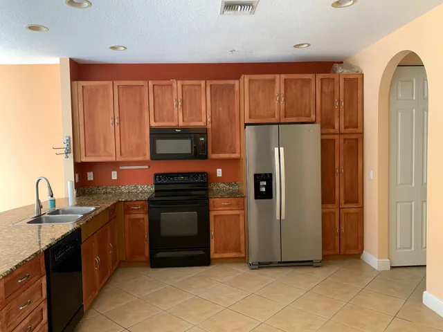 a kitchen with stainless steel appliances granite countertop a refrigerator and a sink