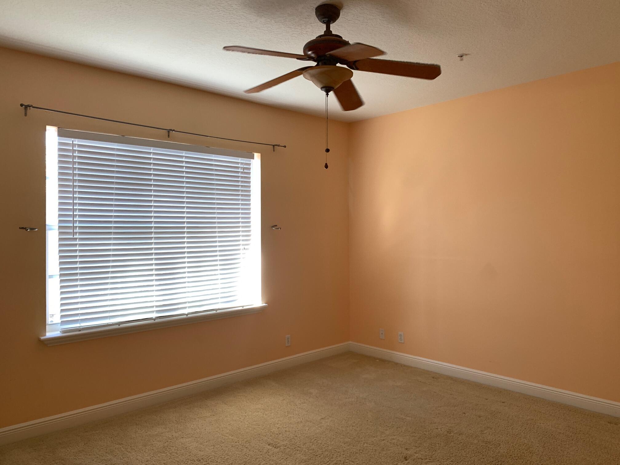 145 Morning Dew Circle Jupiter, FL 33458 - Photo 6 of 12 an empty room with a window and a fan