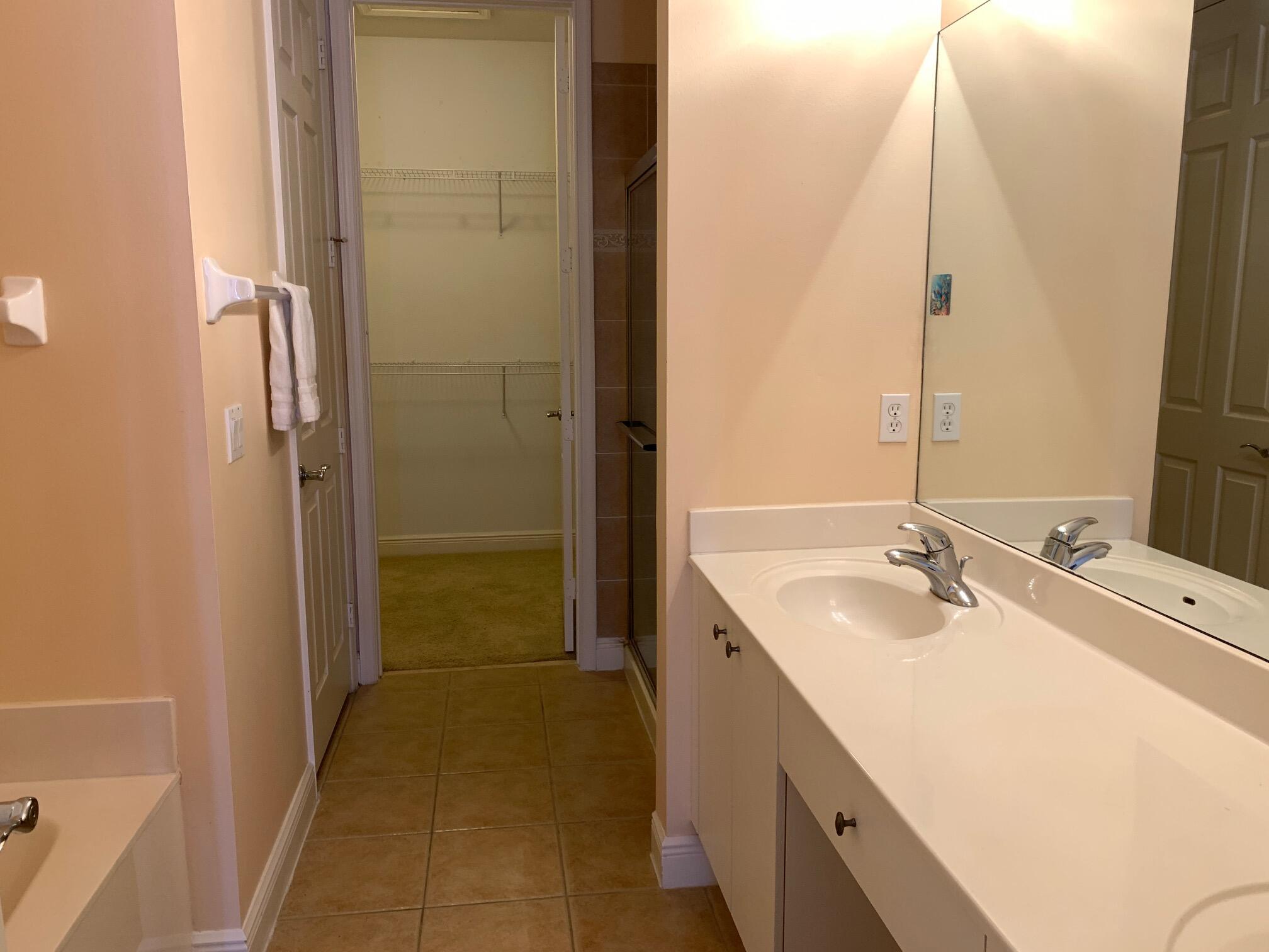 145 Morning Dew Circle Jupiter, FL 33458 - Photo 9 of 12 a bathroom with a double vanity sink and a mirror