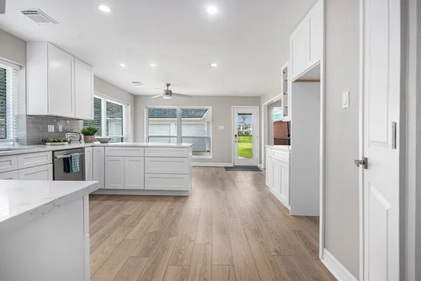 a large kitchen with a center island and stainless steel appliances