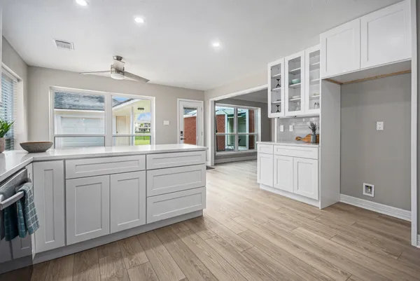 a kitchen with white cabinets and sink