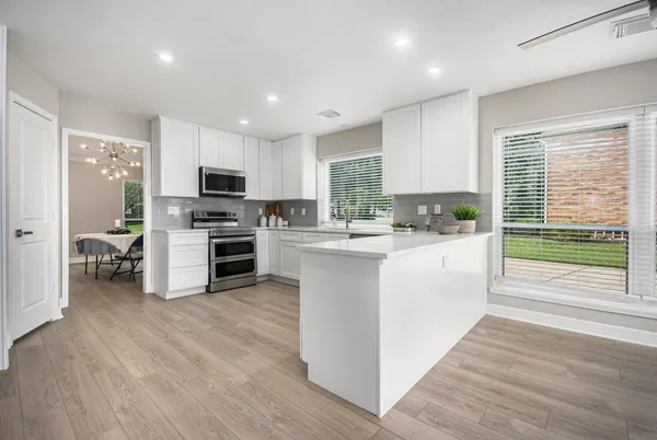 a kitchen with microwave a stove top oven and cabinets
