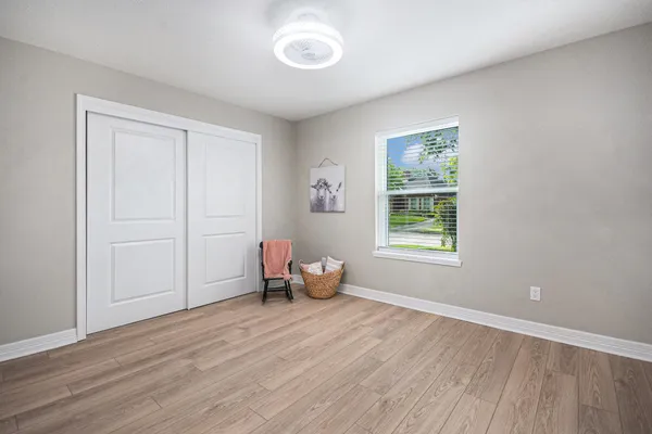 an empty room with wooden floor and windows