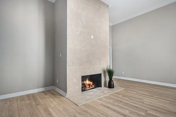 a view of an empty room with a fireplace and a window