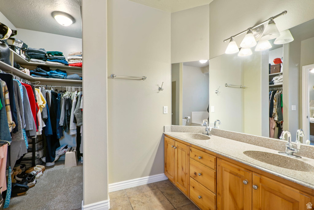 557 South 1470th Street East Springville, UT 84663 - Photo 17 of 46 Primary Bathroom featuring a spacious closet, double vanity, and a textured ceiling