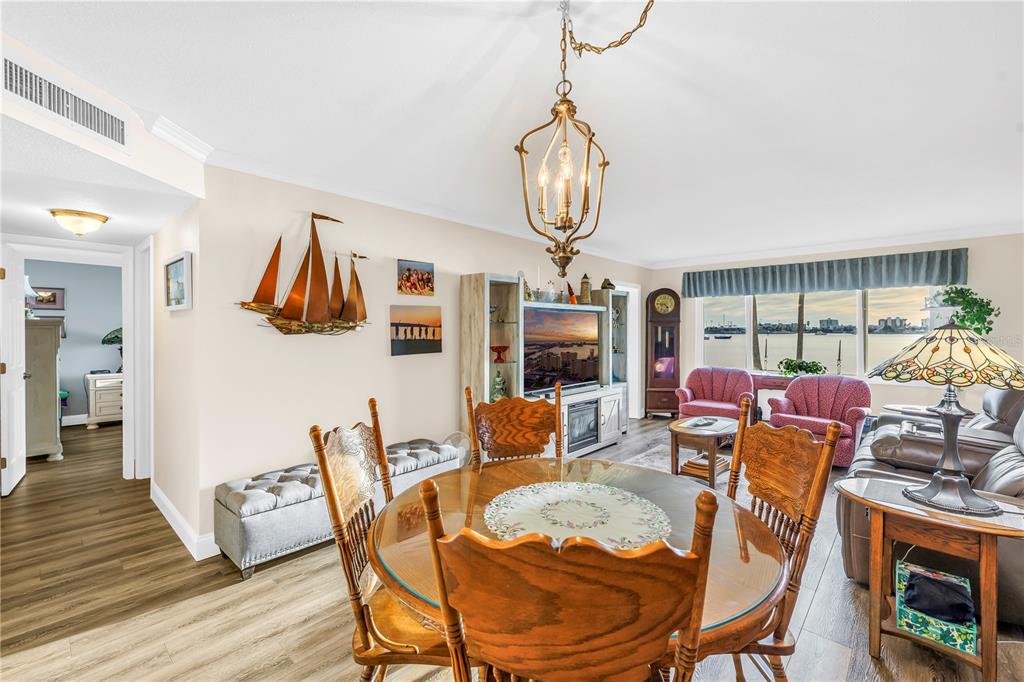 4525 Cove Circle, Unit 102 St. Petersburg, FL 33708 - Photo 27 of 73 a dining room with furniture a chandelier and wooden floor