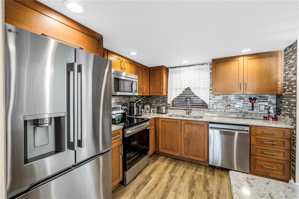 4525 Cove Circle, Unit 102 St. Petersburg, FL 33708 - Photo 4 of 73 a kitchen with granite countertop stainless steel appliances and wooden cabinets