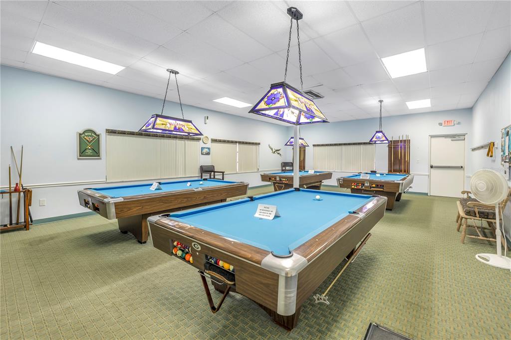 4525 Cove Circle, Unit 102 St. Petersburg, FL 33708 - Photo 61 of 73 a room with pool table and a chandelier