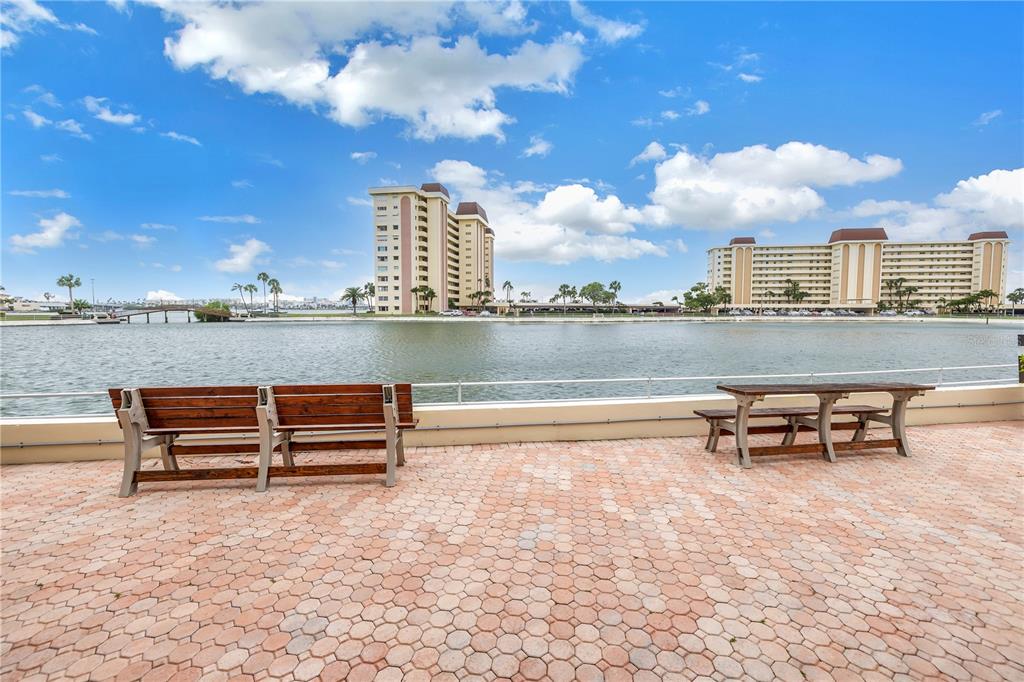 4525 Cove Circle, Unit 102 St. Petersburg, FL 33708 - Photo 62 of 73 a view of a terrace with lawn chairs and wooden fence