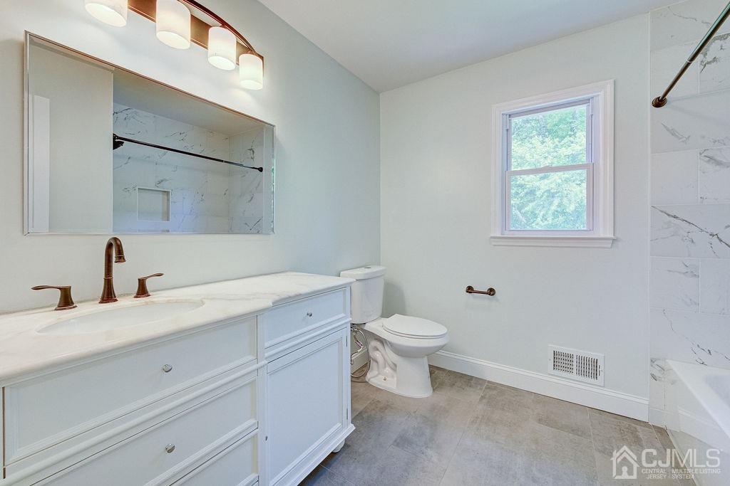 16 Oak Tree Road Monmouth Junction, NJ 08852 - Photo 13 of 29 a bathroom with a toilet a sink a vanity and mirror