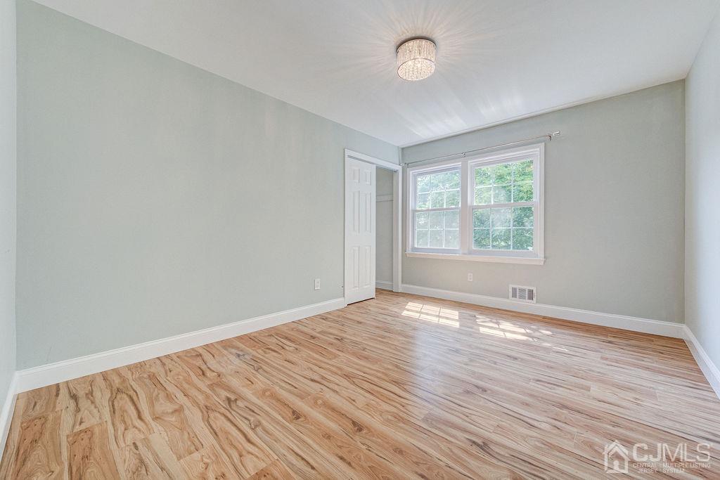 16 Oak Tree Road Monmouth Junction, NJ 08852 - Photo 21 of 29 an empty room with wooden floor and windows
