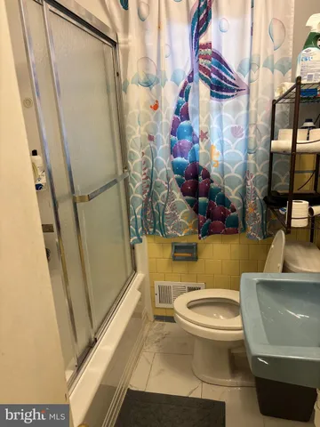 a bathroom with a toilet and a shower curtain