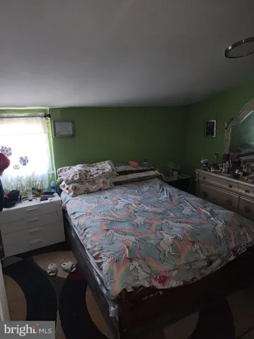 a bedroom with a bed and a view of living room