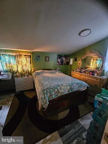 a bedroom with a bed and large windows