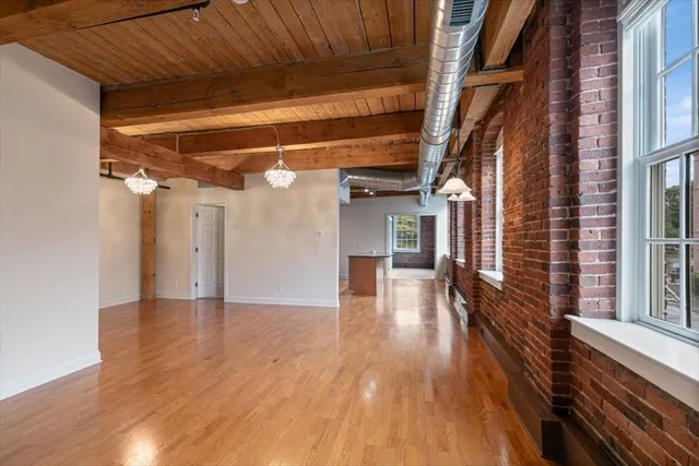 a view of a hallway with entryway wooden floor and door