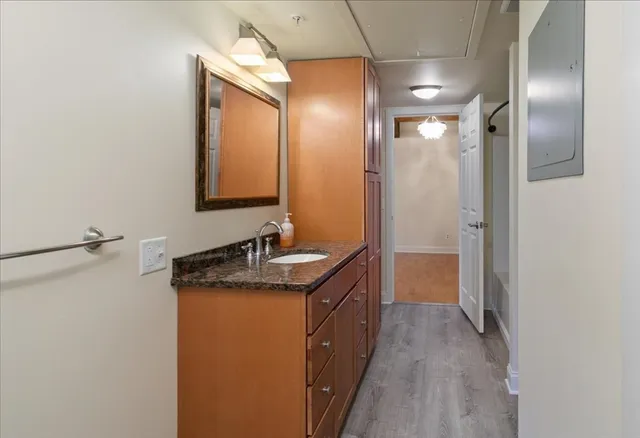 a bathroom with a granite countertop sink a mirror and a shower