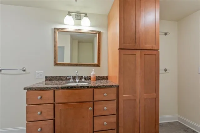 a bathroom with a granite countertop sink and a mirror