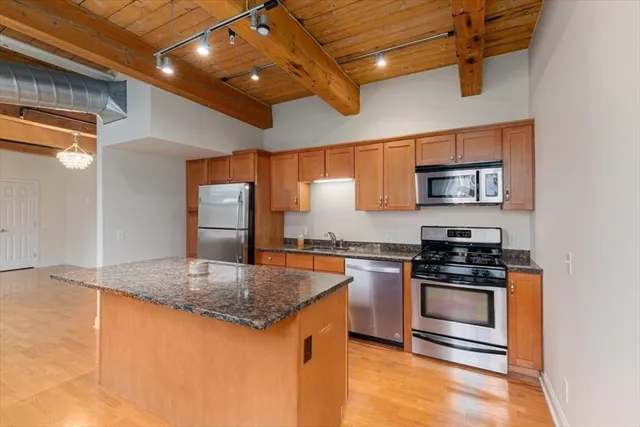 a kitchen with stainless steel appliances granite countertop a stove a sink and a refrigerator