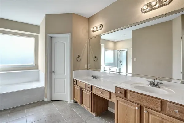 a bathroom with a granite countertop sink mirror and a bathtub