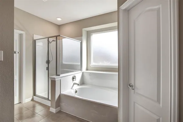 a spacious bathroom with a bathtub and a shower