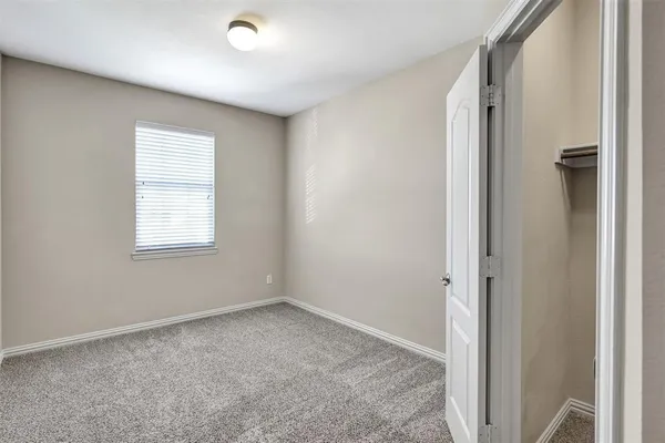 an empty room with windows and closet