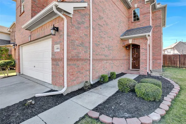 a view of a house with brick walls and a yard