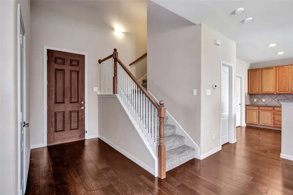 a view of a hallway with wooden floor and staircase