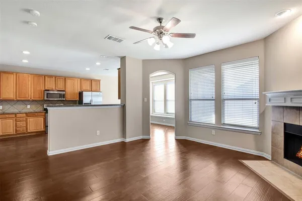 an open kitchen with a refrigerator and a stove top oven