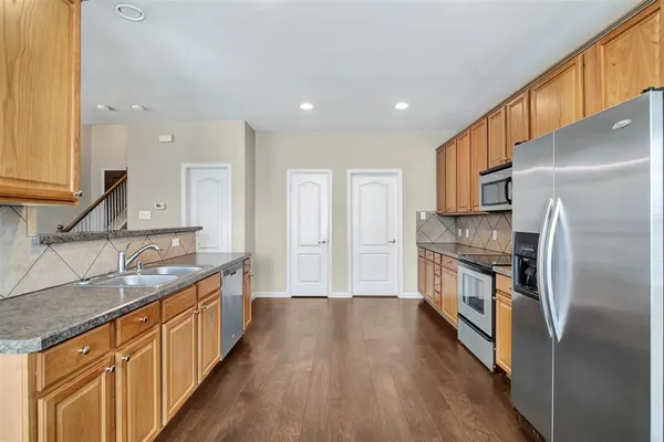 a kitchen with a sink refrigerator and microwave