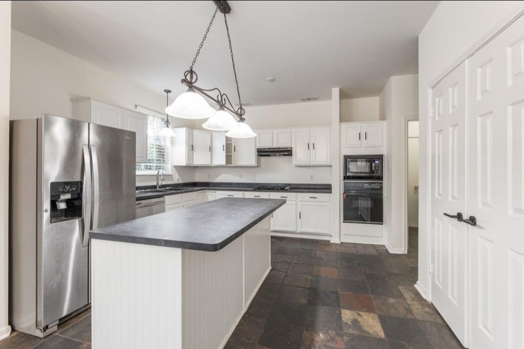2515 Falcon Ridge Street Pearland, TX 77584 - Photo 14 of 31 a kitchen with stainless steel appliances granite countertop a refrigerator a sink and a stove