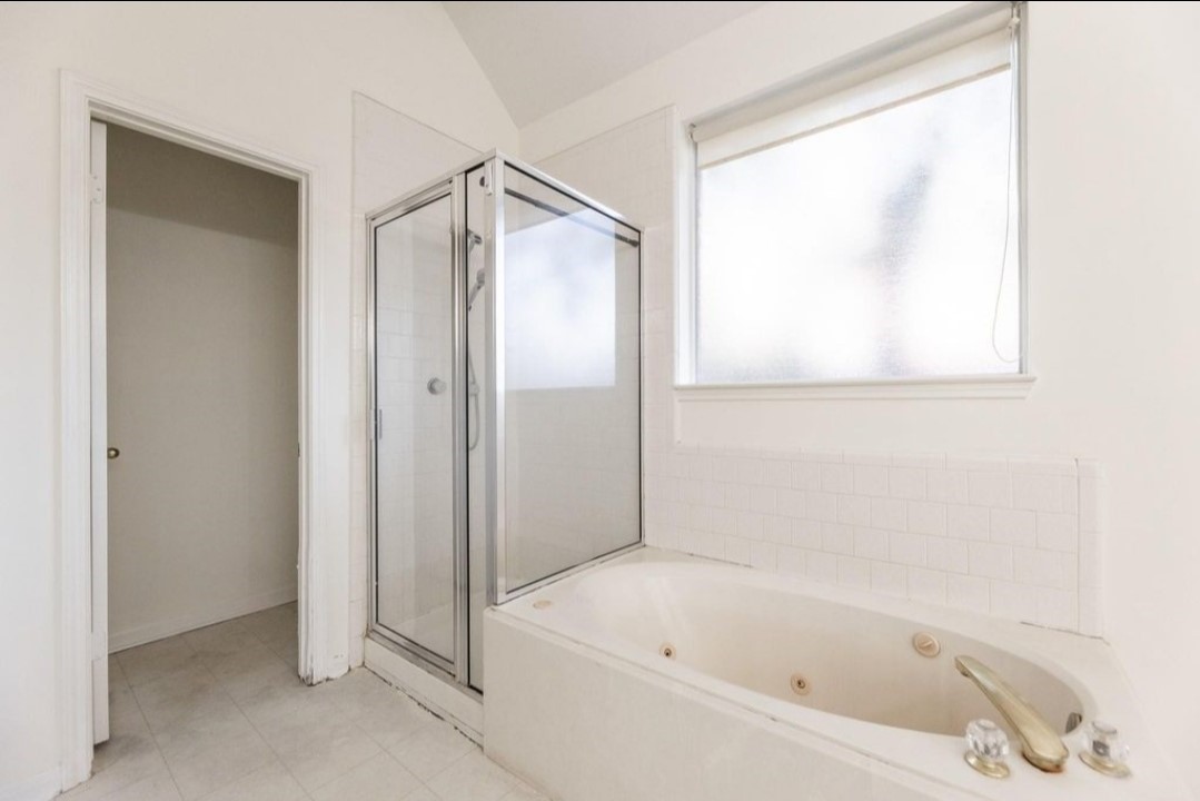 2515 Falcon Ridge Street Pearland, TX 77584 - Photo 22 of 31 a bathroom with a bathtub and a shower