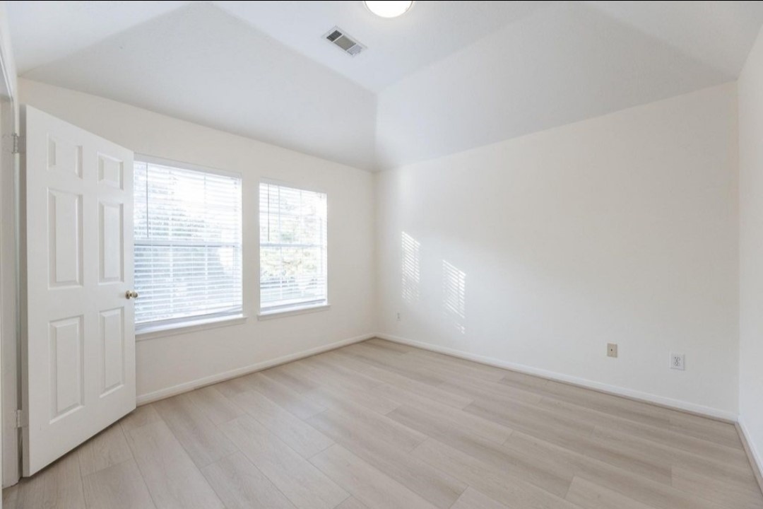 2515 Falcon Ridge Street Pearland, TX 77584 - Photo 26 of 31 an empty room with wooden floor and windows